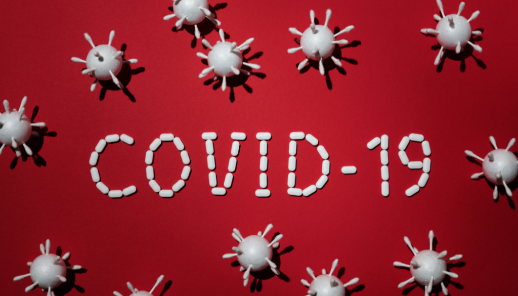 Covid-19 on red backdrop with icons of the virus sprinkled around the title